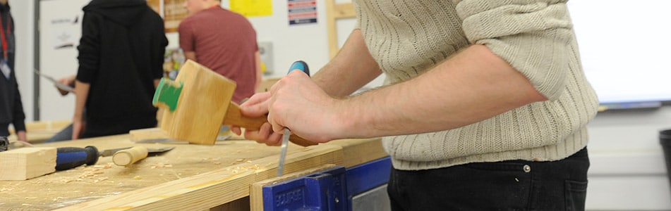 using a hammer in carpentry class